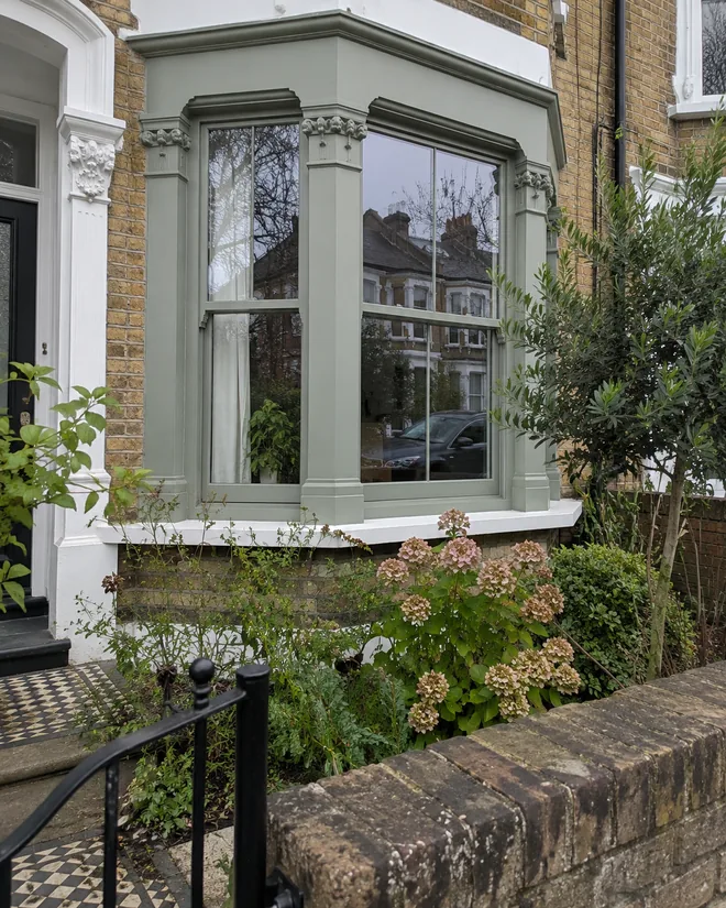 Sage-green timber replacement sashes in a traditional bay